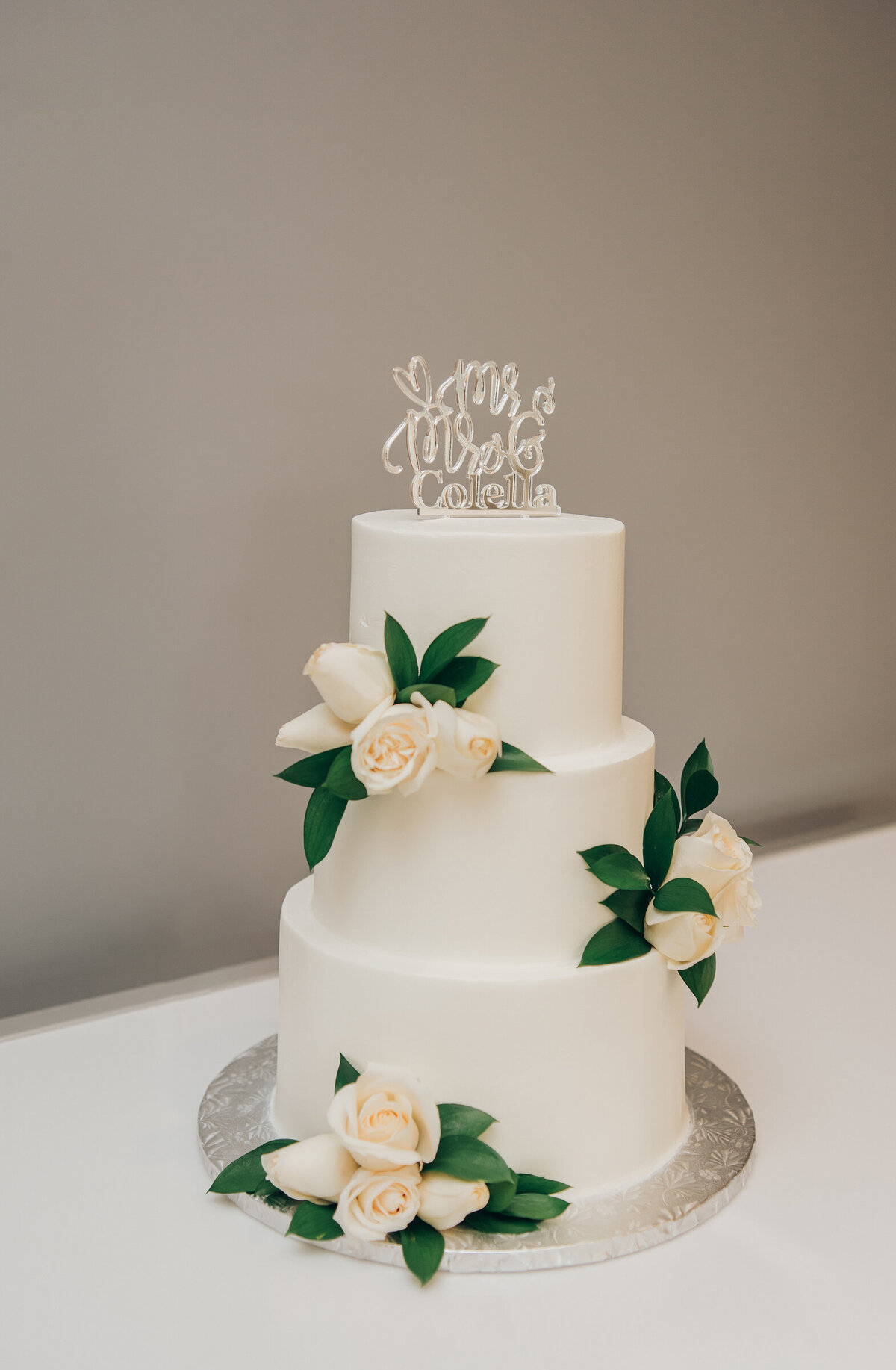 Simple, elegant, white wedding cake with real white flowers