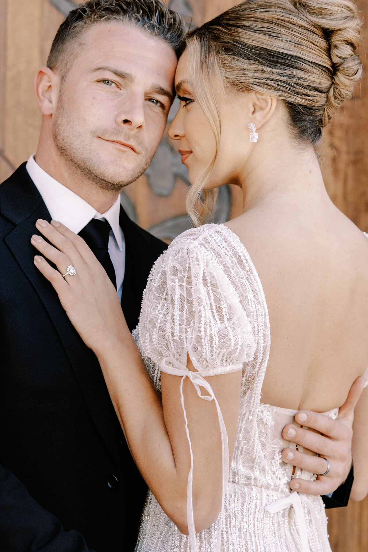 Bride in updo and short sleeved beaded wedding gown with bows and groom at Palais Namaskar Morocco for a destination wedding photographed by Italy photographer