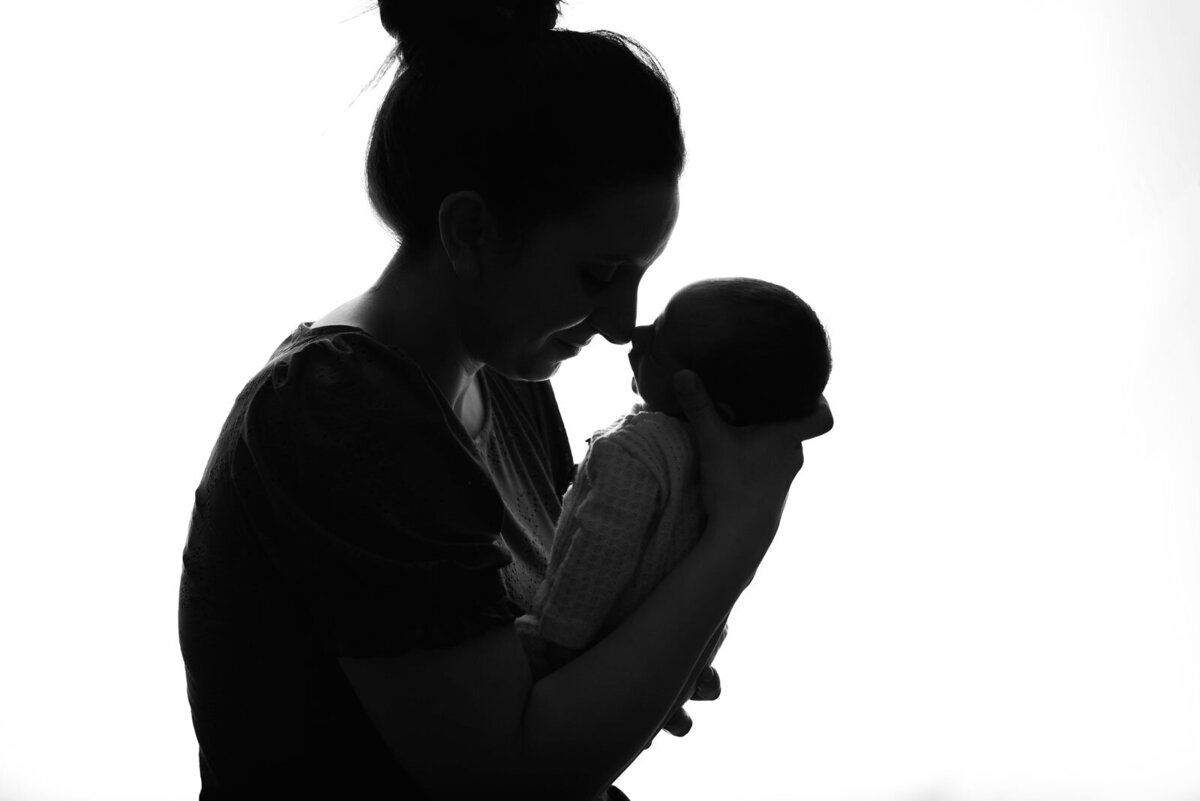 mom and baby backlit by st. louis newborn photographer