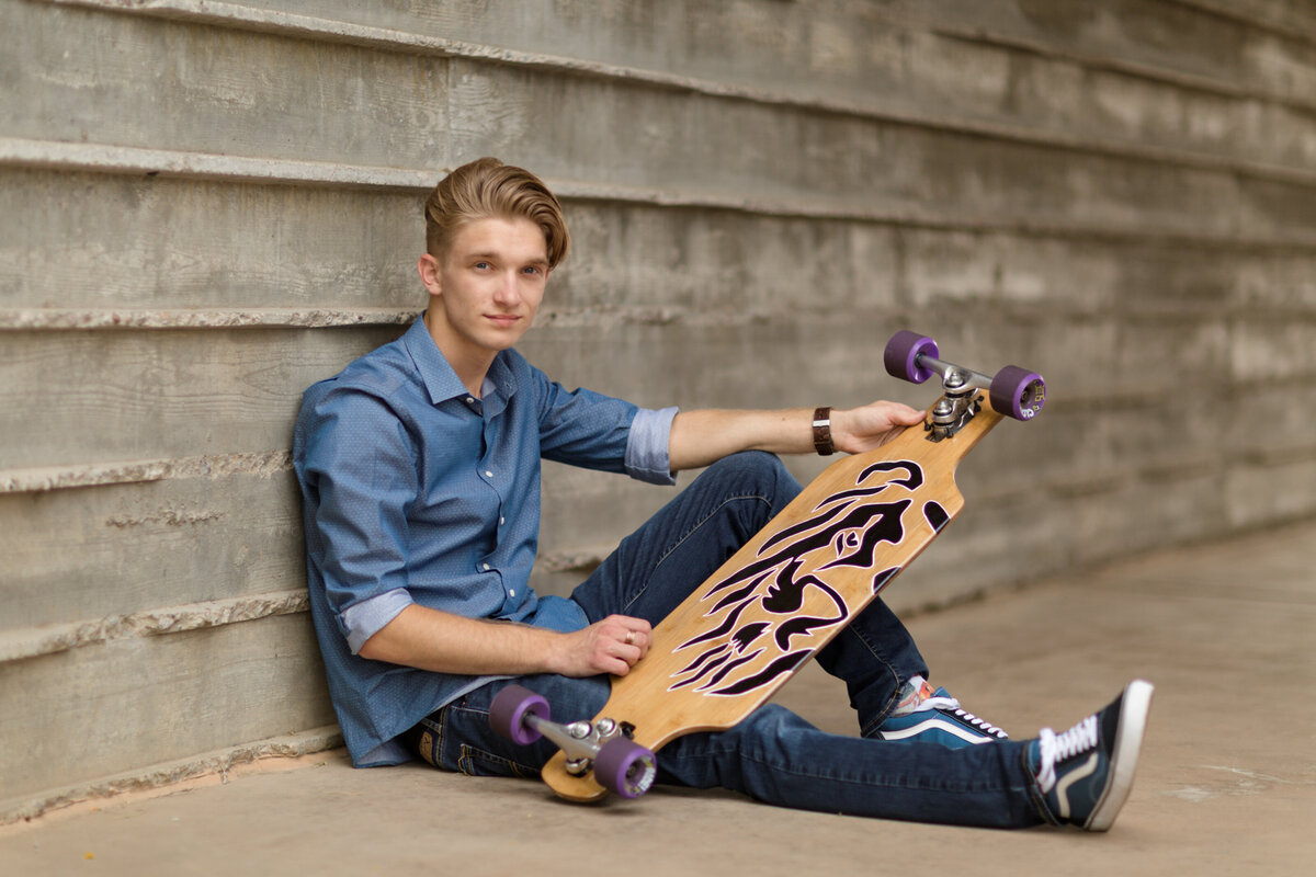 senior posing with skateboard