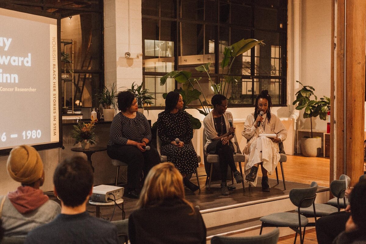 Candid photo of 5 panelists at a Black Her Stories event