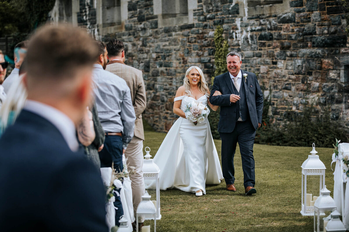 A bride and the father of the bride walking down the aisle