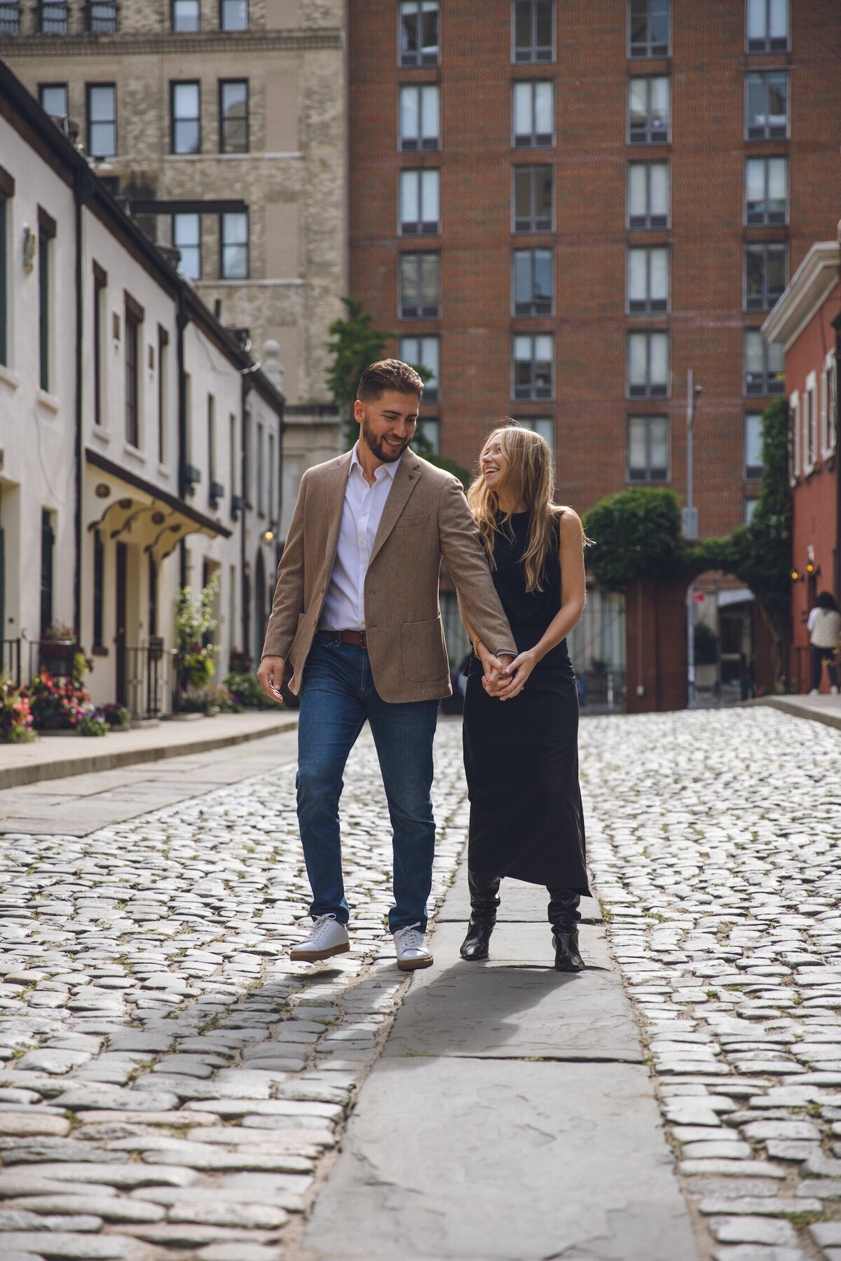 Couple laughing and celebrating together on the cobblestone street.