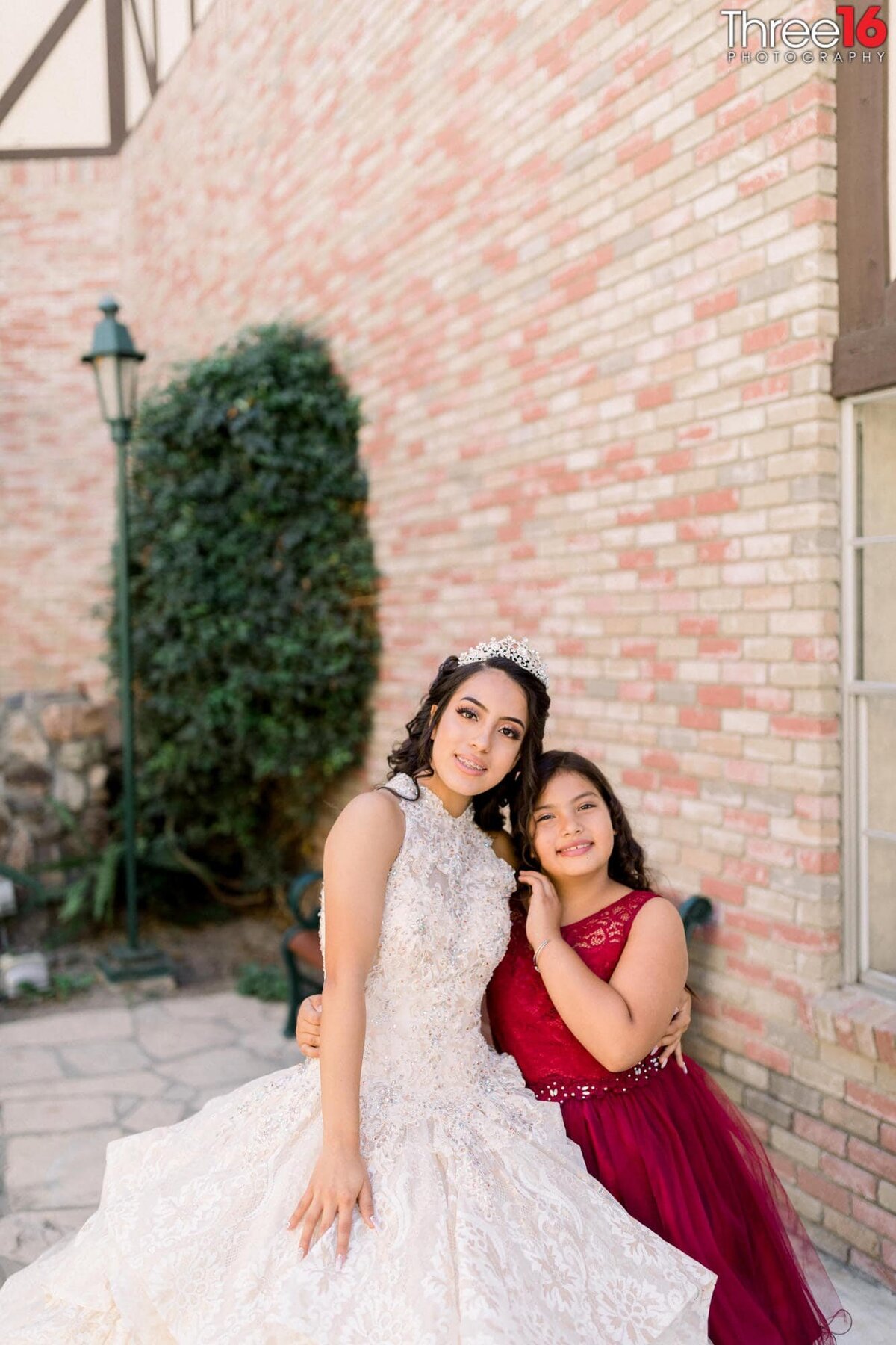 Young girl poses with the teen girl while celebrating her quinceanera