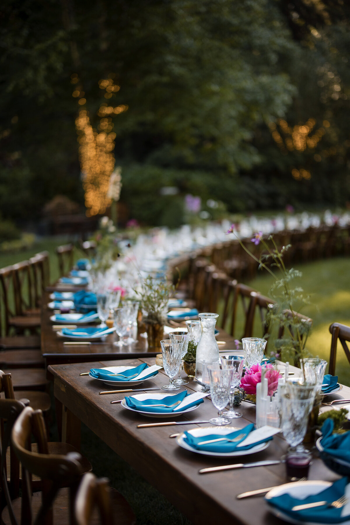 A curved reception table on the lawn at a destination wedding at Nestldown in Los Gatos, California
