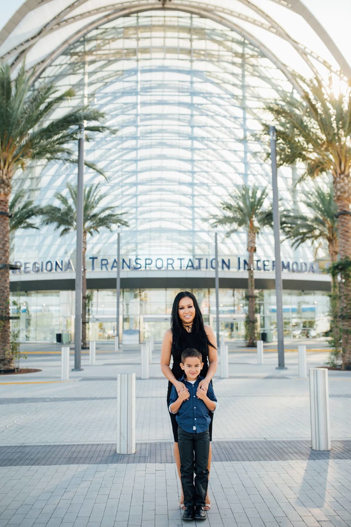 A mother stands behind her young son during a photo session at the ARTIC Train Station in Anaheim