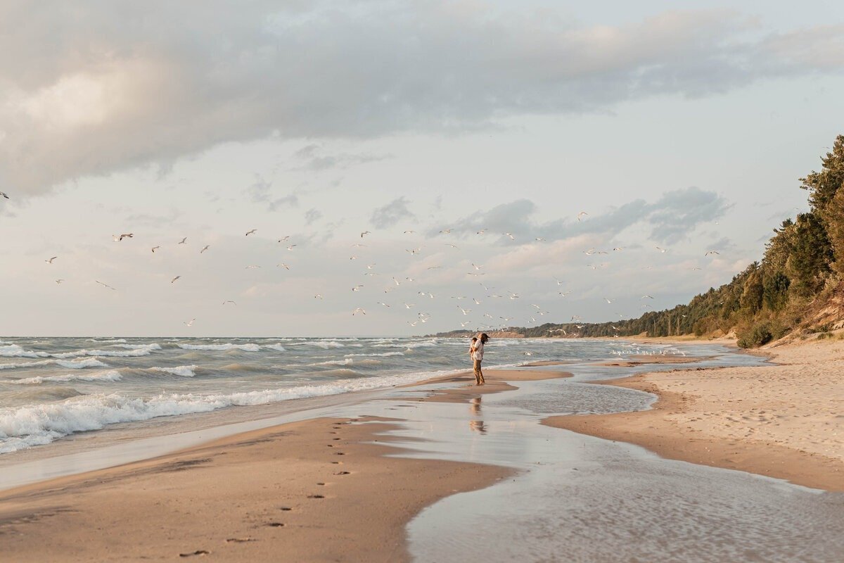 Family walking the beach at sunset captured by West Michigan photographers