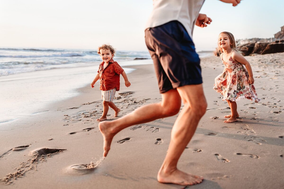 San Diego Family Photographer captures children running through beach during beach family photos