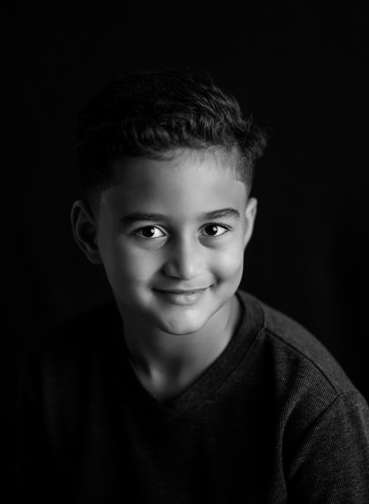Deacon posing in moody studio lighting black and white