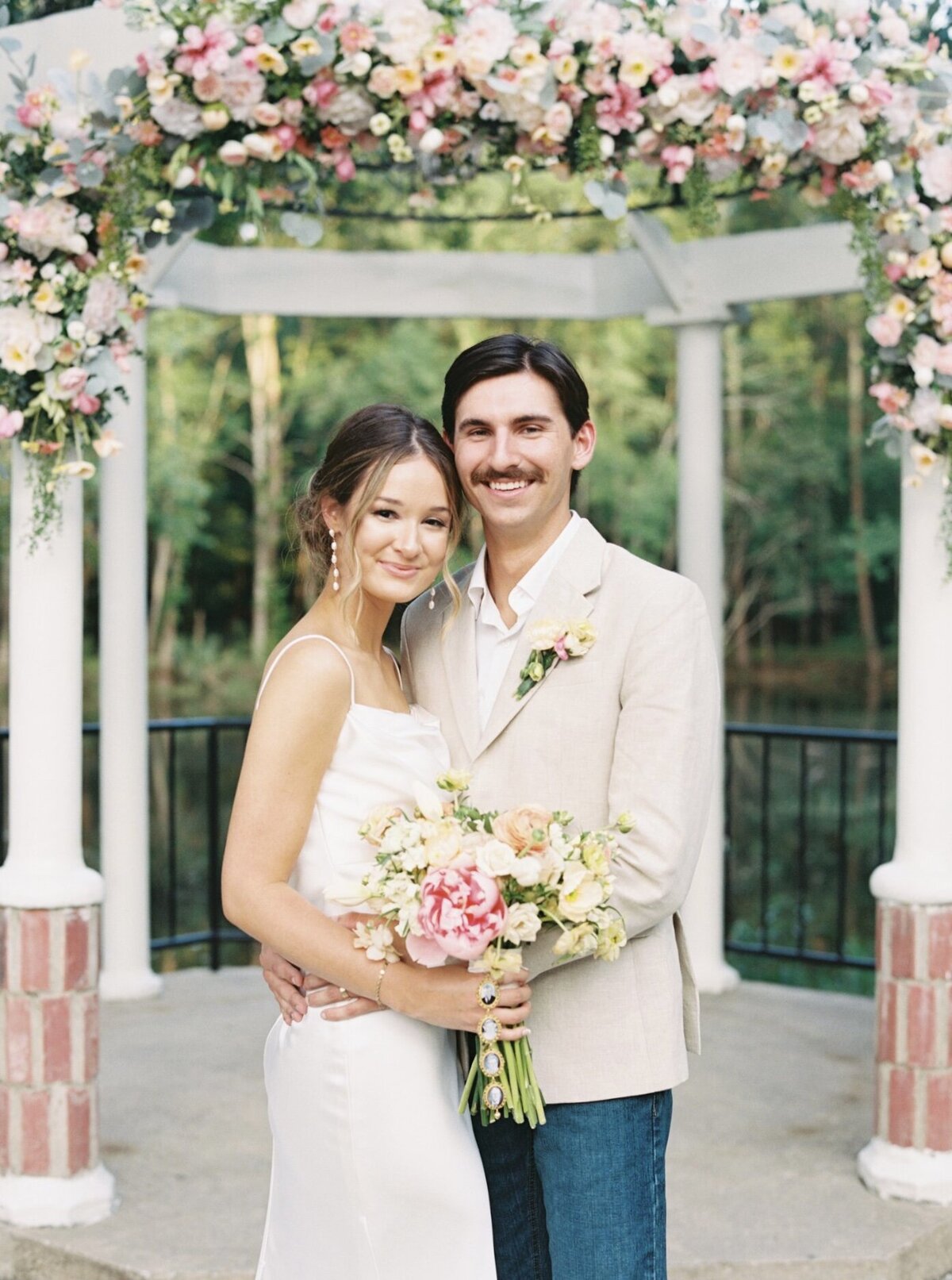 Bride and groom surrounded by vibrant spring florals during their wedding, captured on film by Morgan Alysse, Louisiana film photographer.