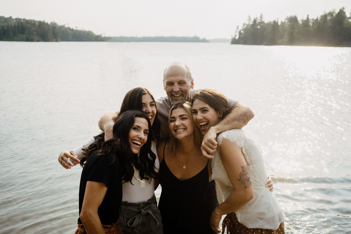group of friends embracing by lake