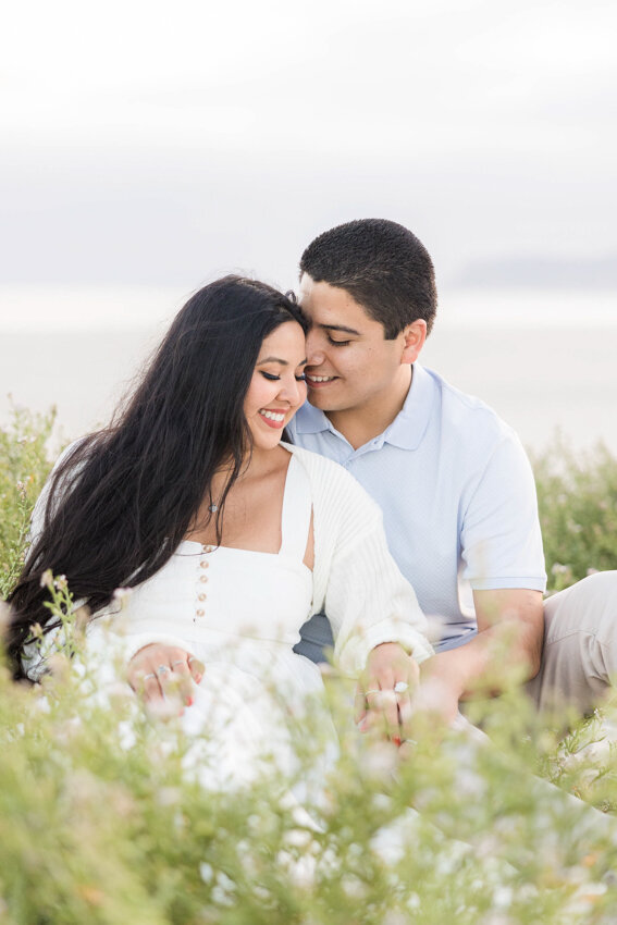 engaged-couple-sitting-in-flowers-Coronado-San-Diego