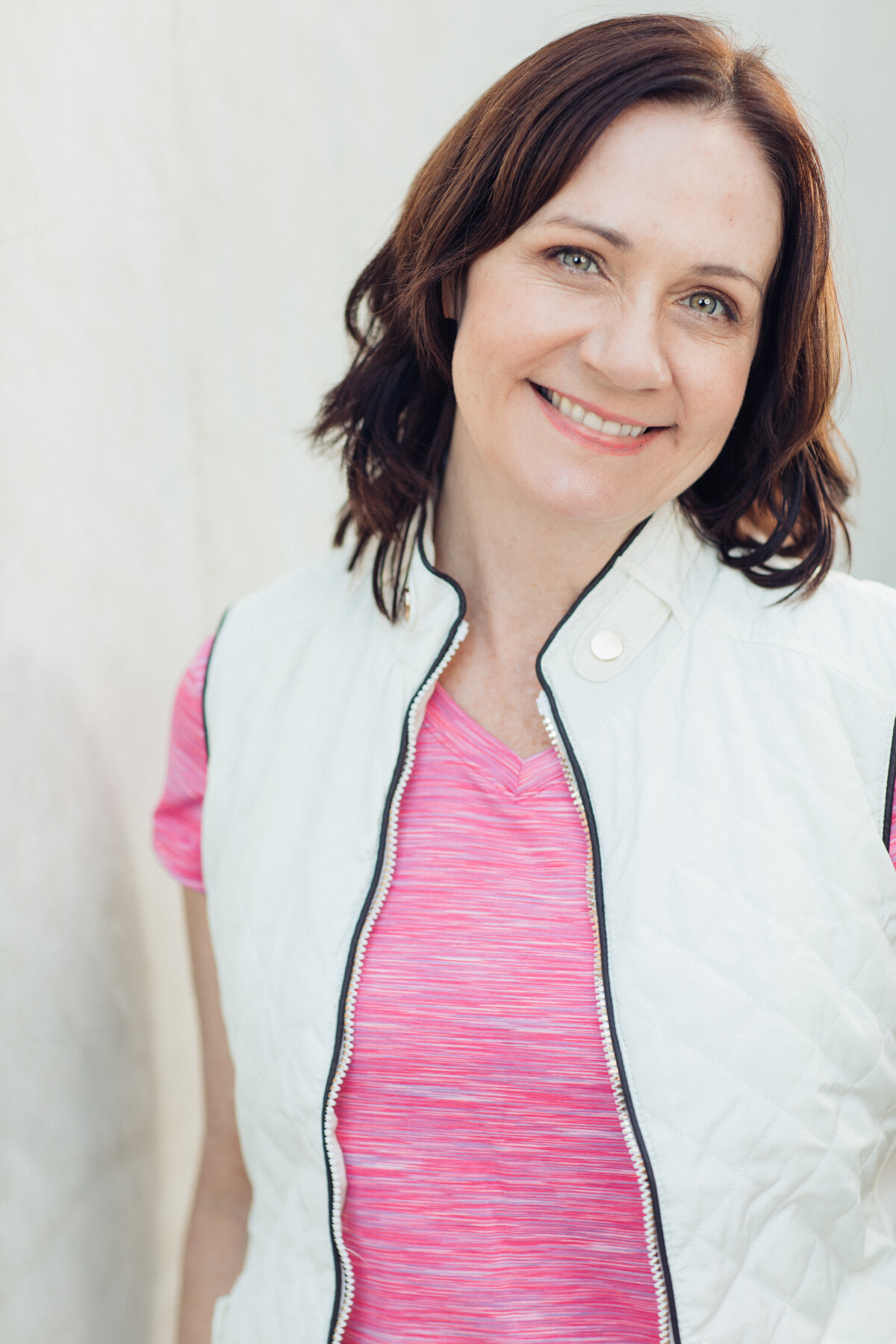 Headshot Photograph Of Woman In Outer White Vest  And Inner Pink Shirt Los Angeles