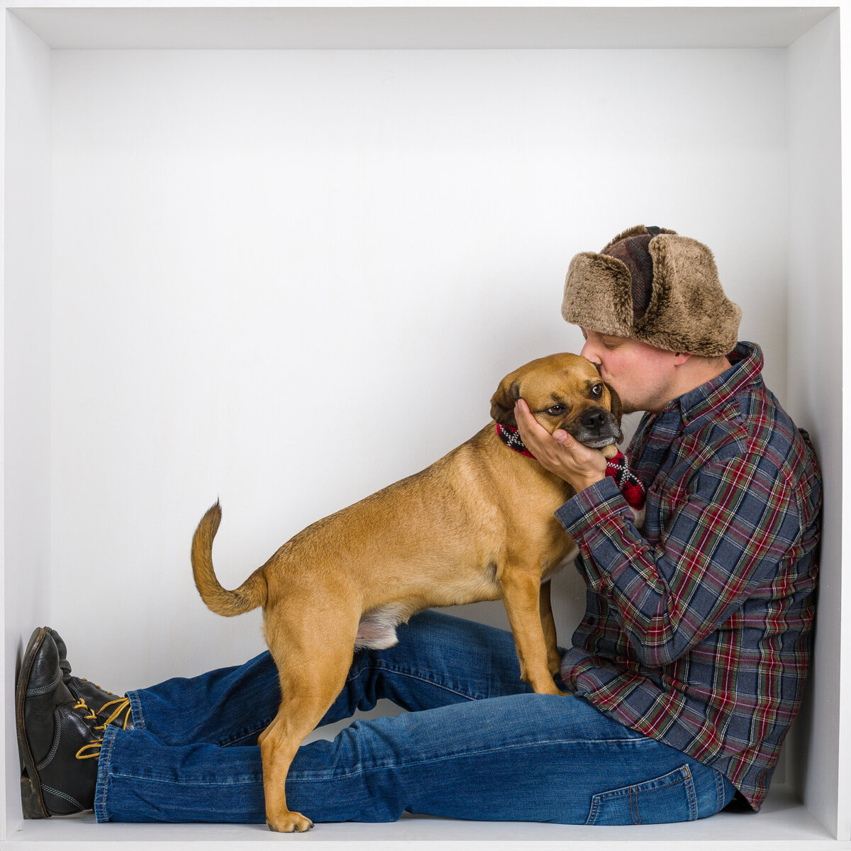 Headshot and branding photographer Travis from Fox & Brazen in  a white box holding a dog