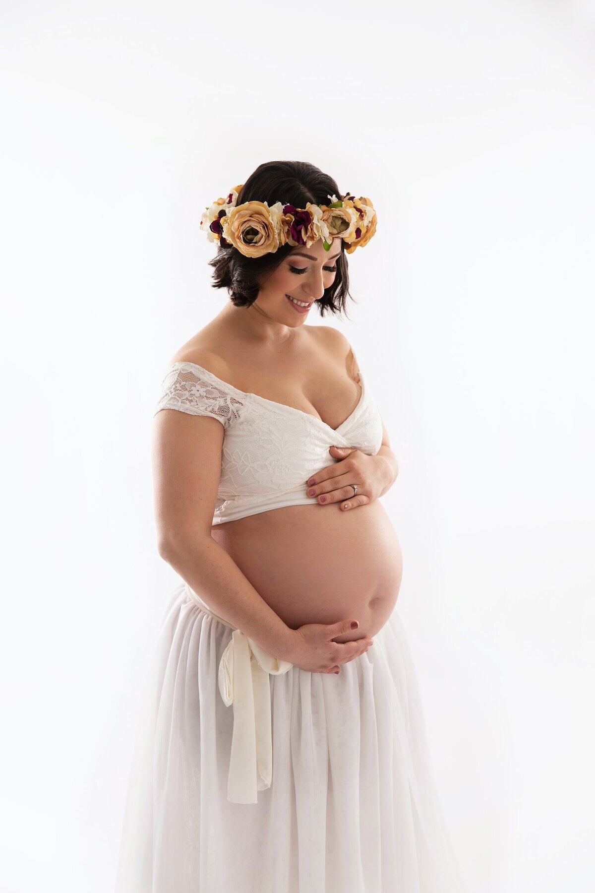 Maternity studio portrait with flower crown and two piece dress