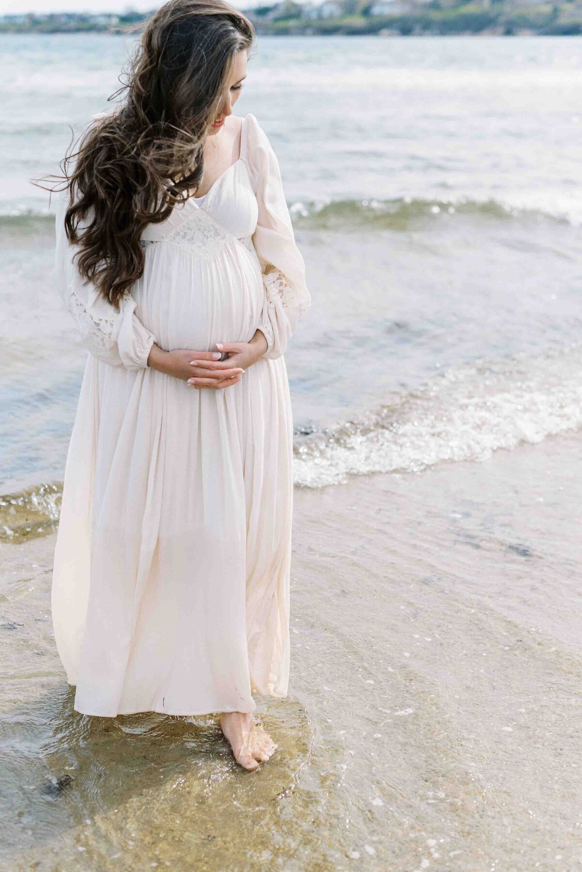 Richmond maternity photography | Light and airy photo of a pregnant mother holding her belly and walking through the surf by Jacqueline Aimee Portraits