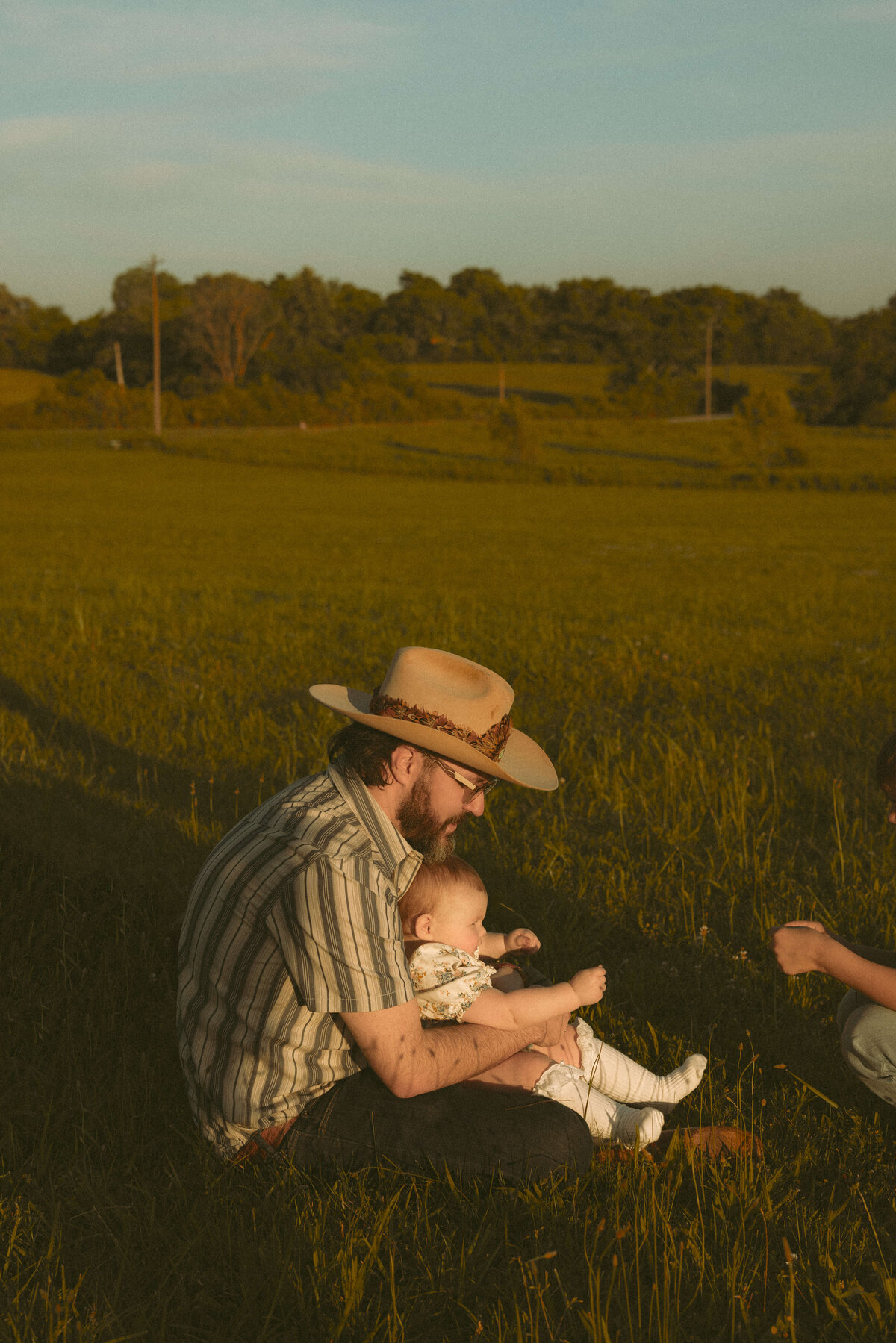 Family holding hands and walking together during Nashville TN sunset photography session