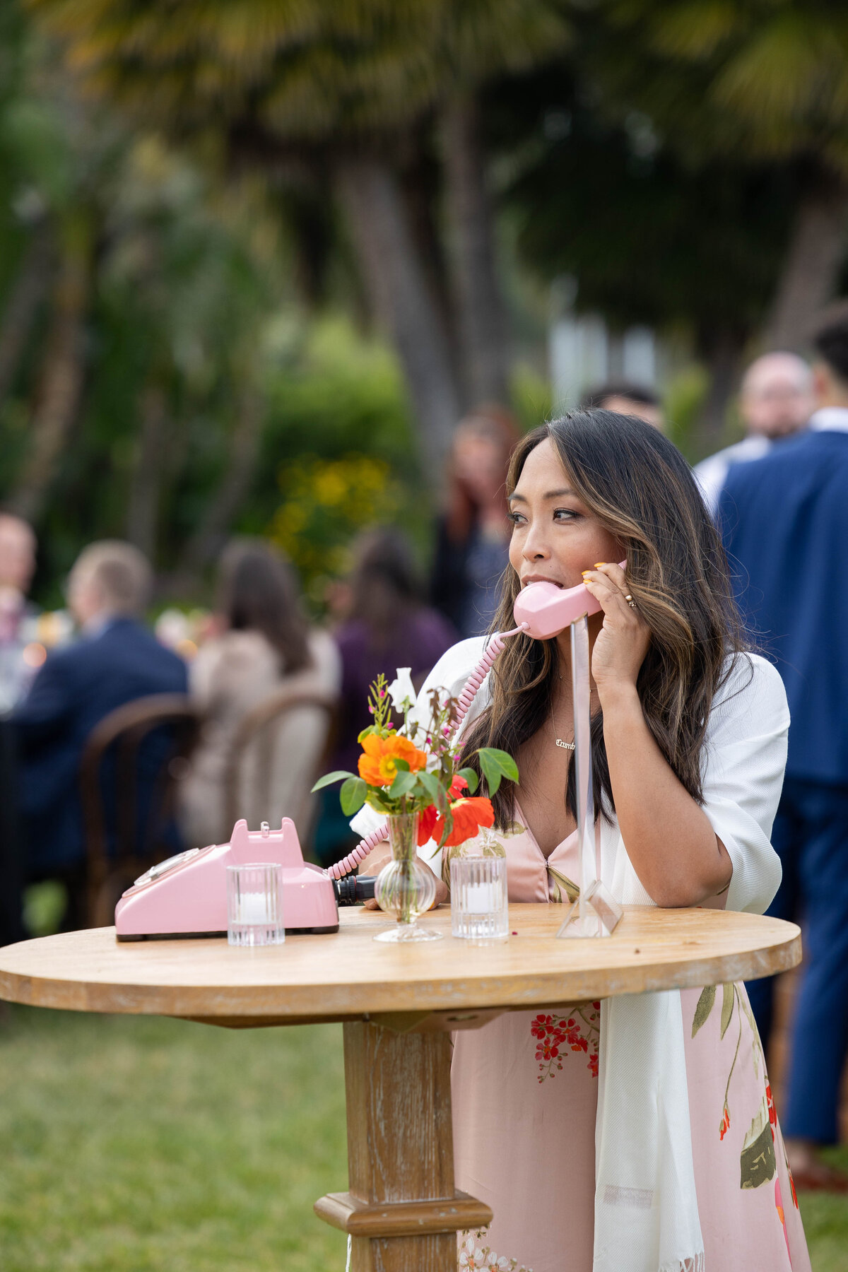 Young Filipino woman talking on a pink rotary phone