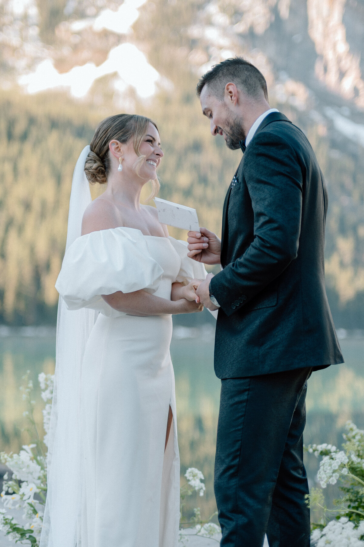 Couple exchanging vows at scenic outdoor ceremony with mountain backdrop