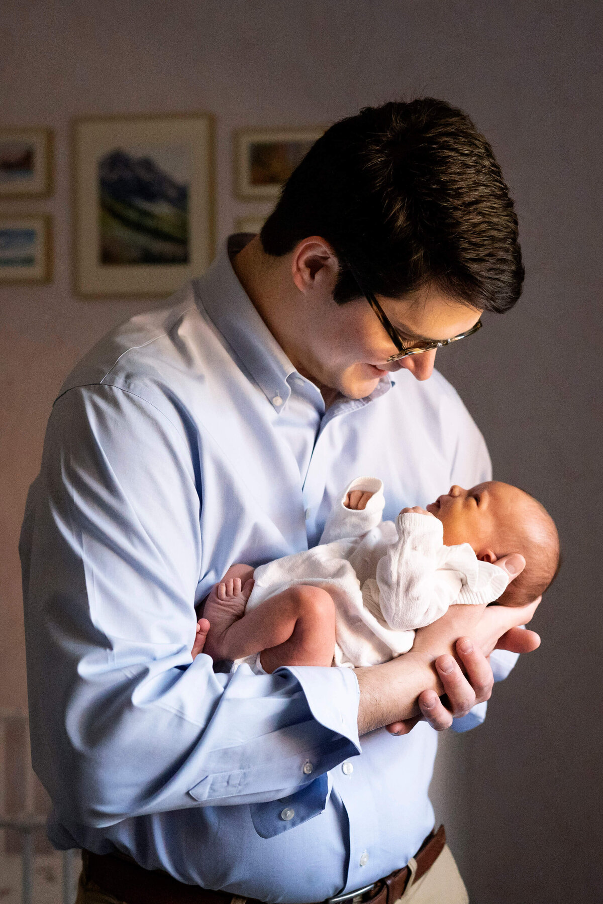 Father holding newborn girl by the window