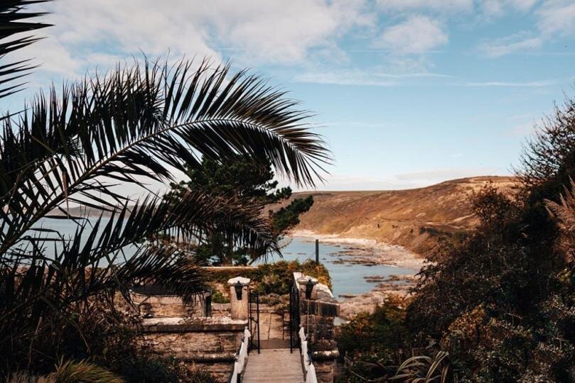 A walkway leading to a fort with the sea in the background