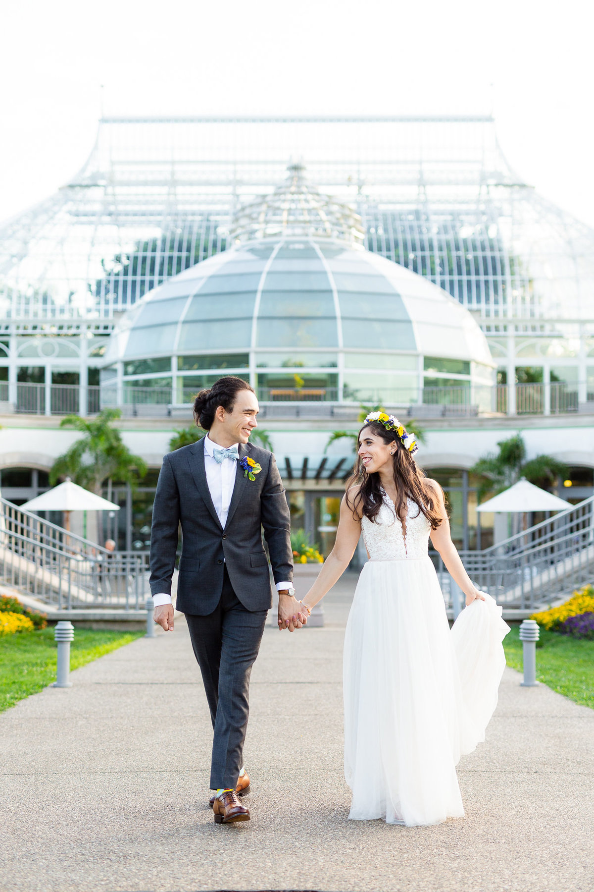 Destination wedding couple holding hands walking in front of phipps conservatory and botanical gardens