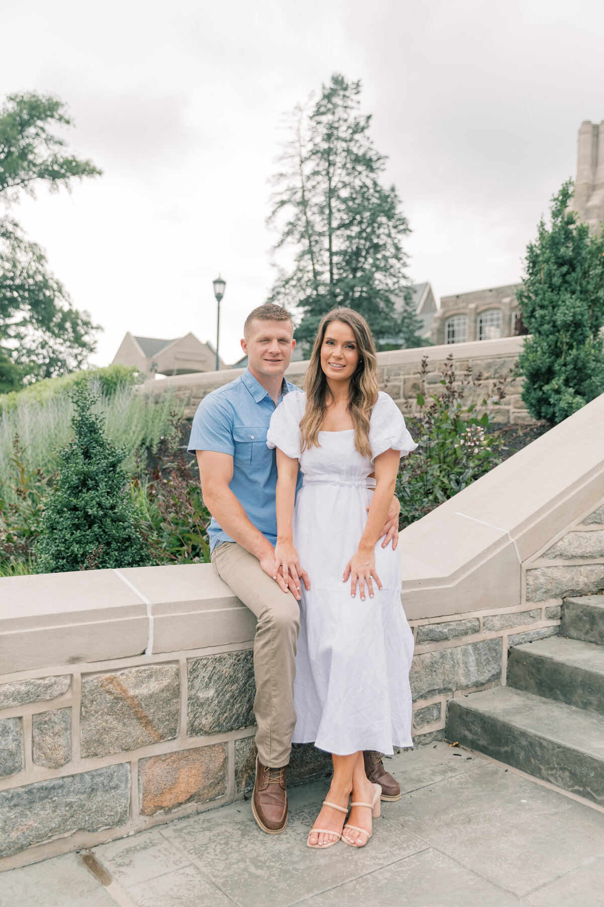 Couple sitting on wall for engagement session photos