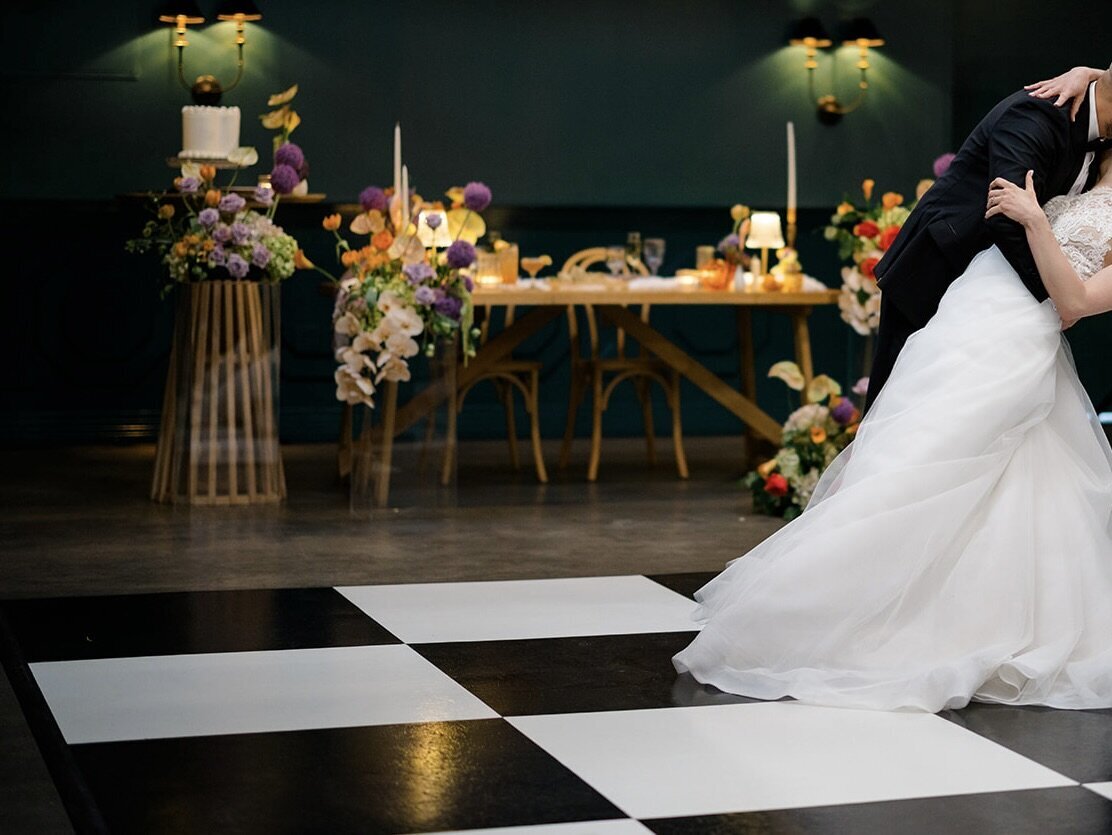 A bride and groom dancing in front of an eclectic design at The Fig House in LA