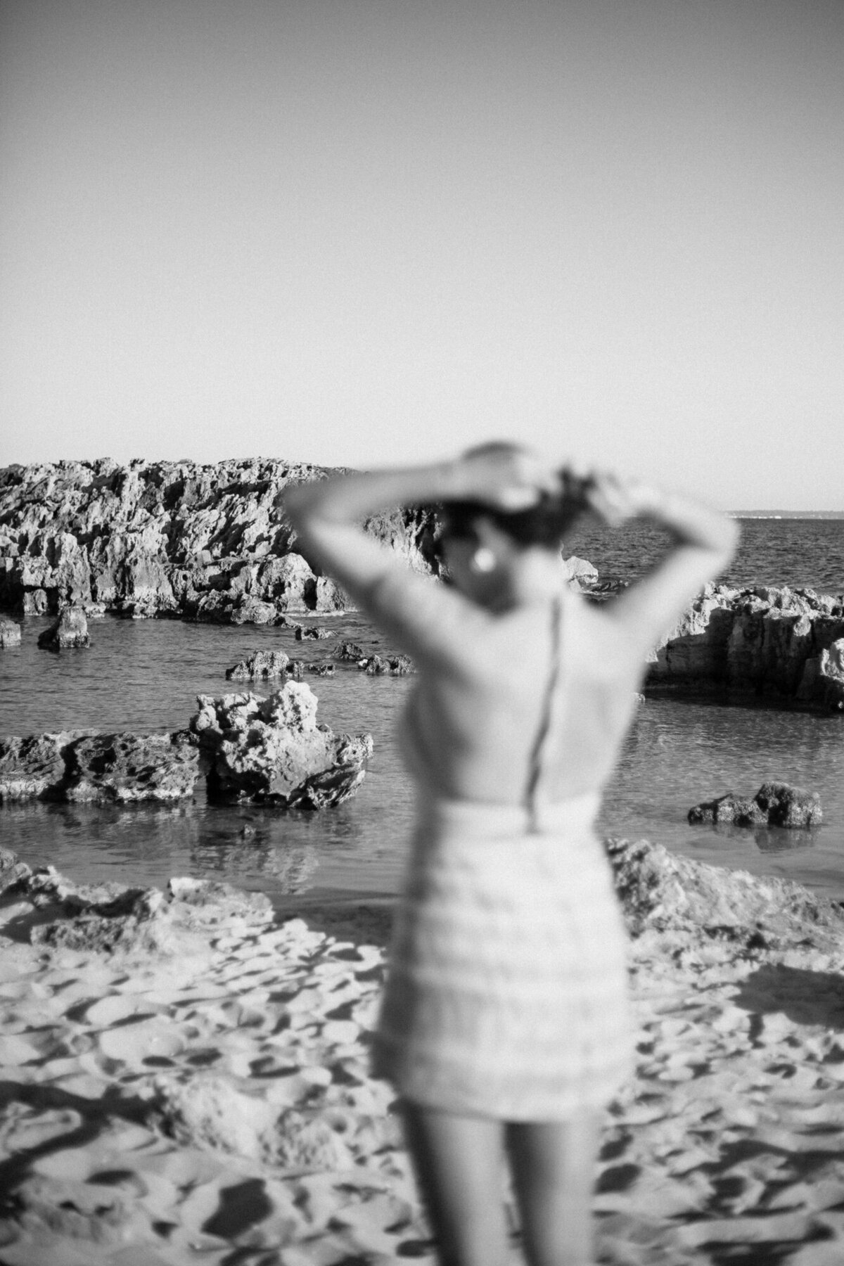 A woman is out of focus while the beach in the background is sharp