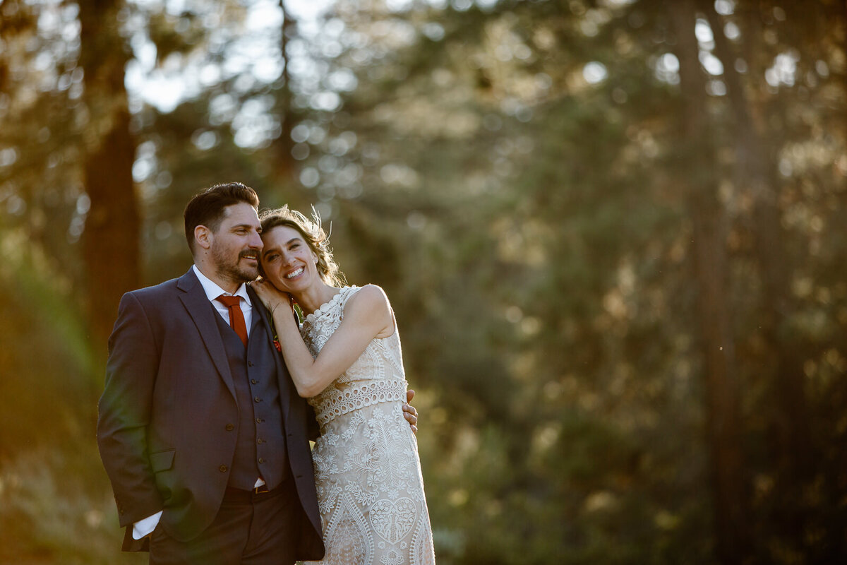 Ali and Brian embrace one another in a forest.