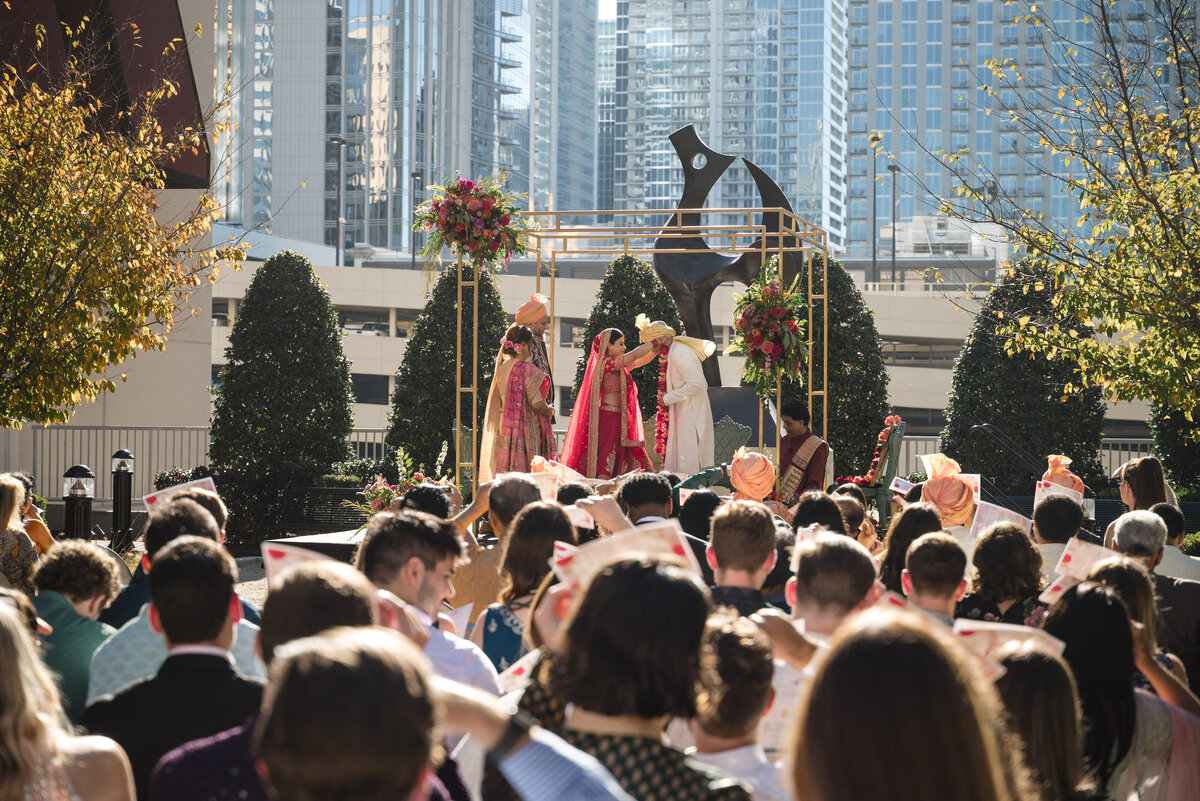 Traditional Indian wedding ceremony with bride and groom exchanging garlands at the Grand Bohemian Hotel Charlotte, beautifully captured by an experienced Indian wedding photographer in Charlotte.