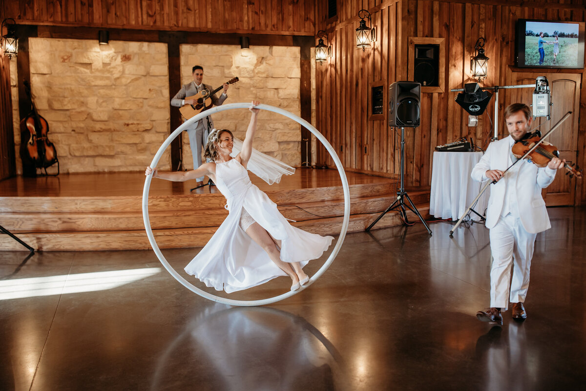 Bride performing inside a large hoop, being accompanied by a violinist