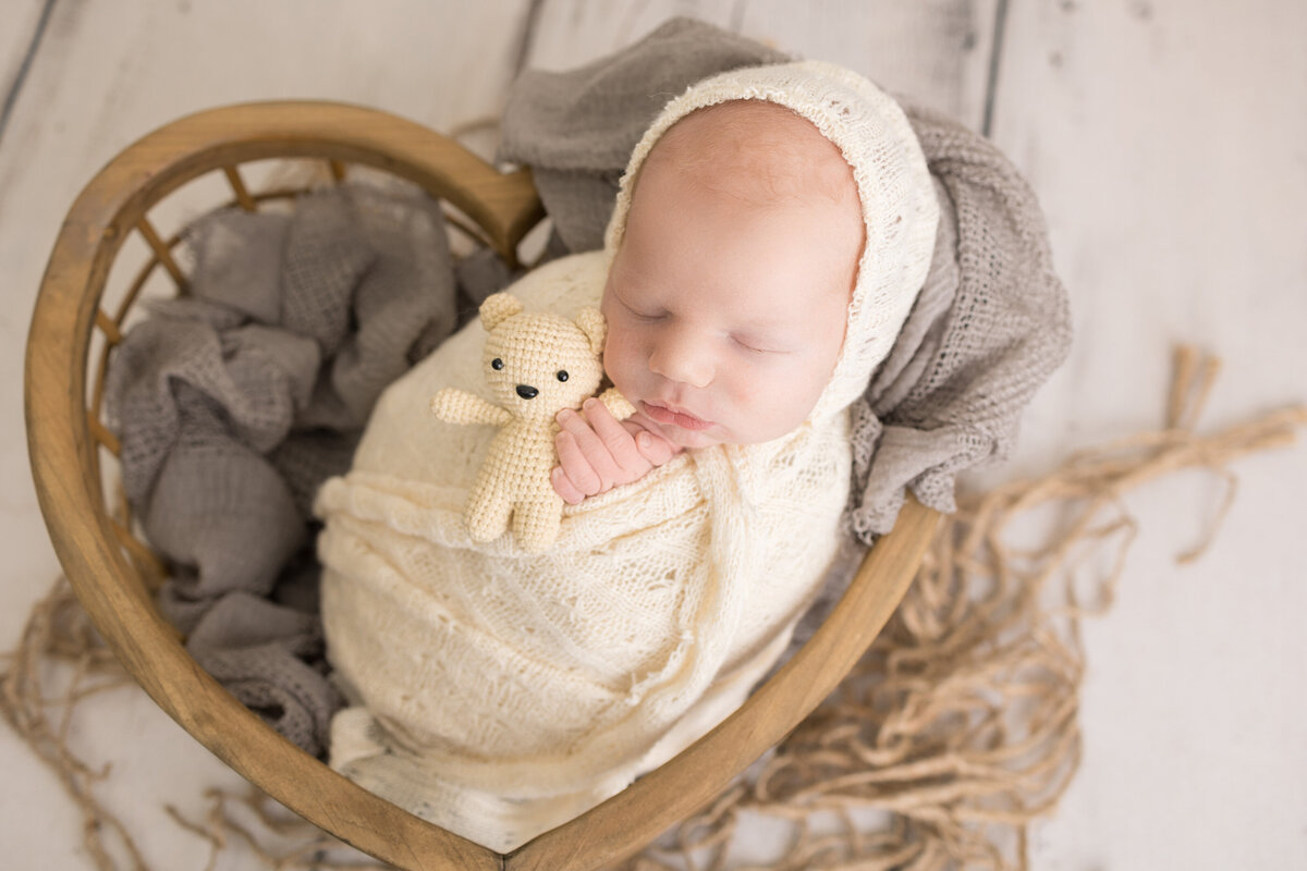 A newborn baby posed in a heart shaped prop for their south jersey newborn session