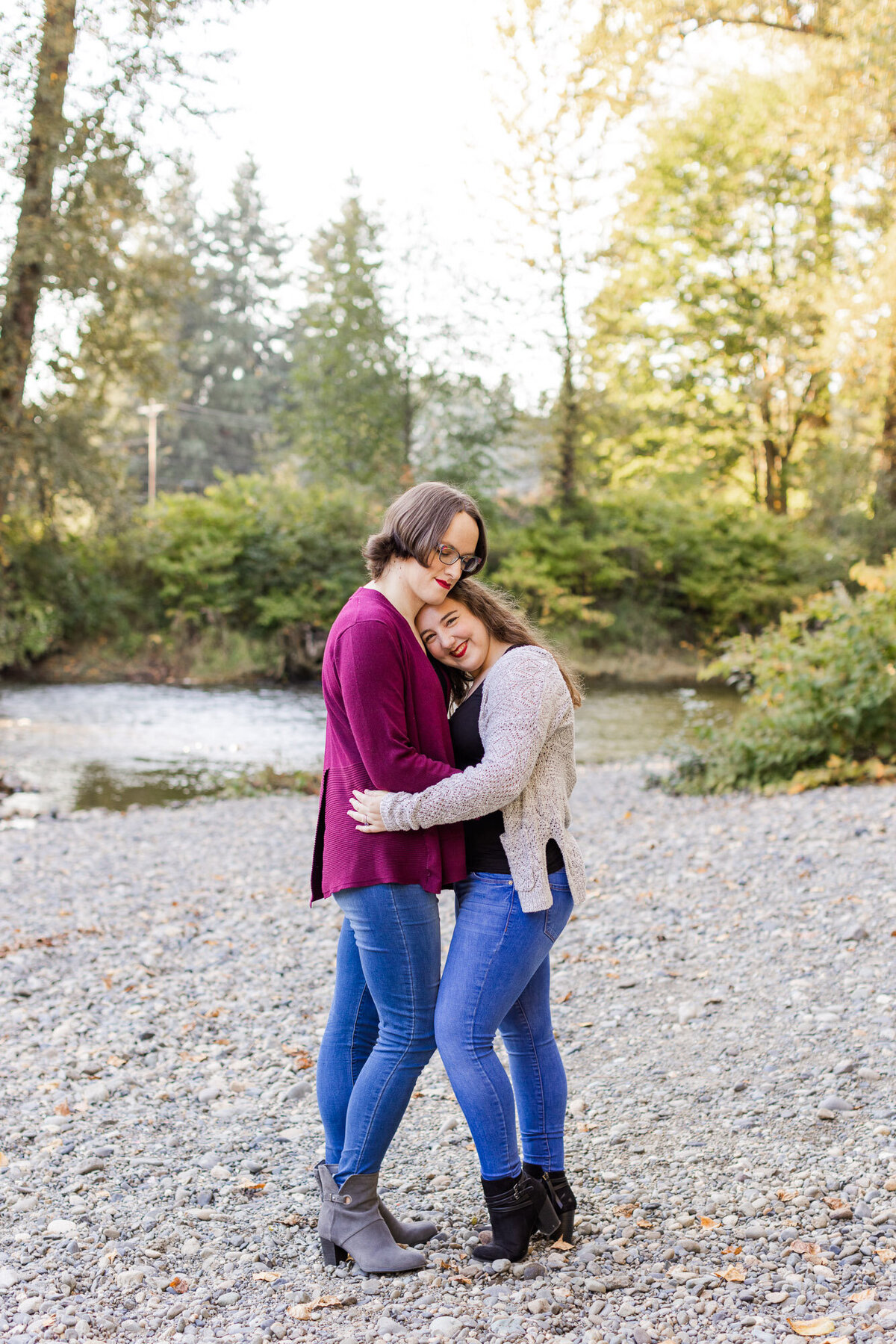 PNW LGBTQ river engagement session at Snohomish river happy couple hugging and smiling candid photo by Joanna Monger Photography