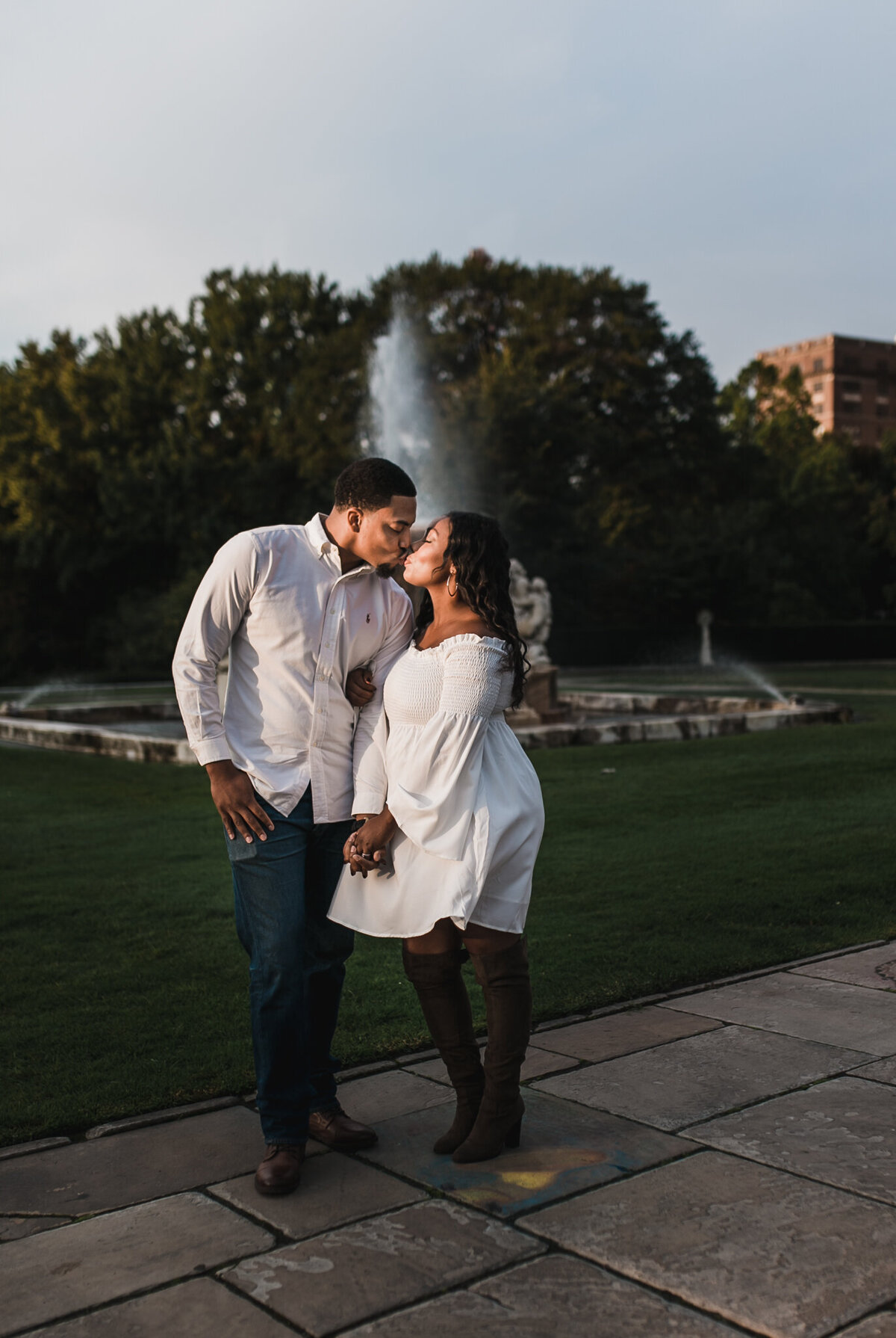 Pregnancy photoshoot with soon to be mom and dad holding hands outside.