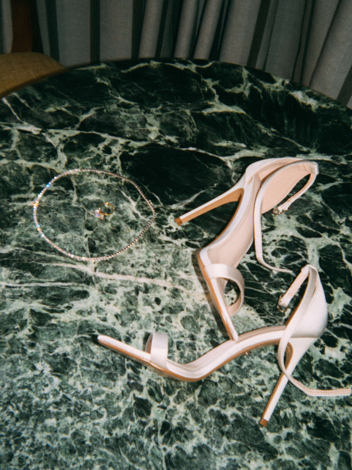 Bridal heels and jewelry styled on green marble table at Soho House Rome