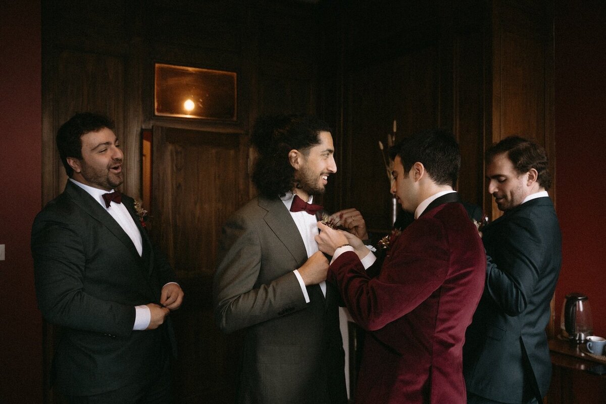 Marié ajustant les détails du costume d'un de ces témoins avant la cérémonie. Photo Kamescop, spécialiste du reportage mariage en Bretagne.
