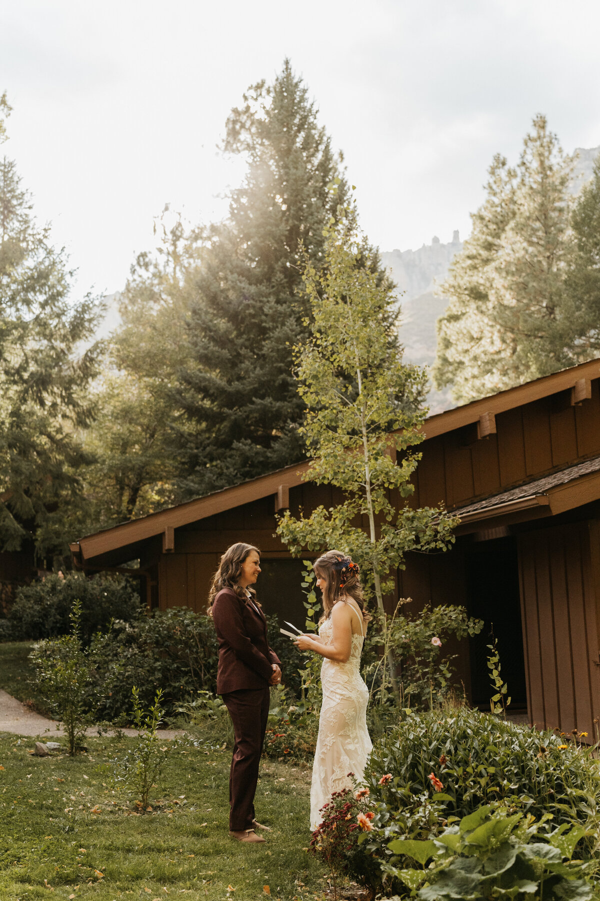 A wedding couple standing alone as one reads a letter to the other 