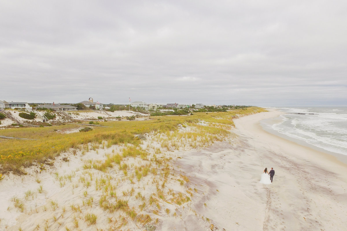 distant bride and groom walking on the beach photo at Oceanbleu Westhampton