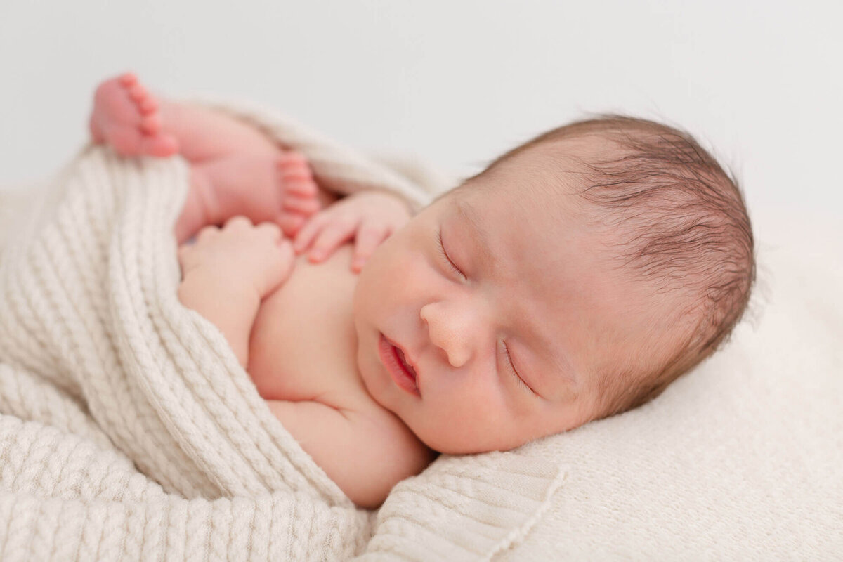 sleeping baby on beige backdrop