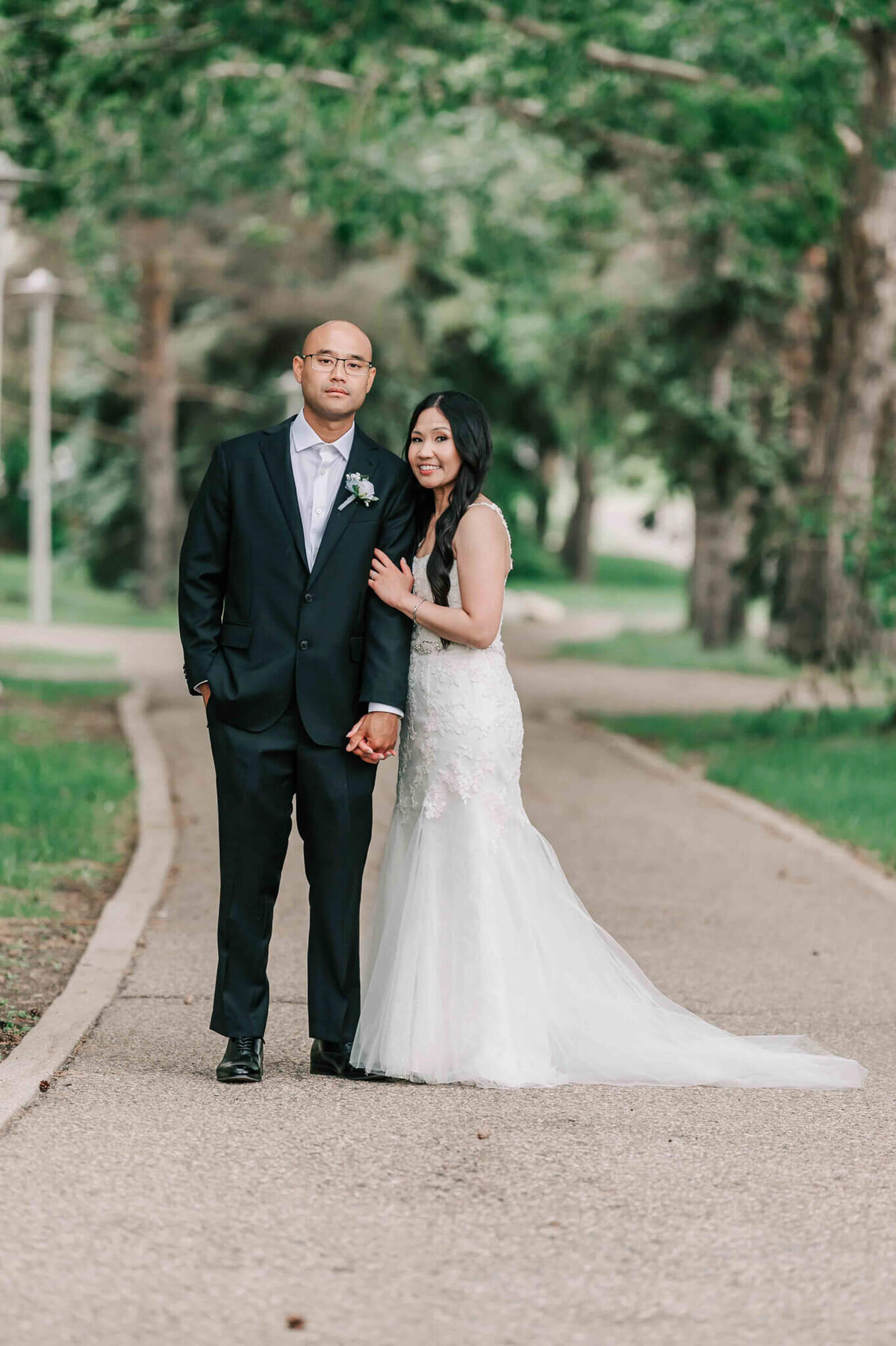 Bride and groom standing on a path at the university of Saskatchewan.