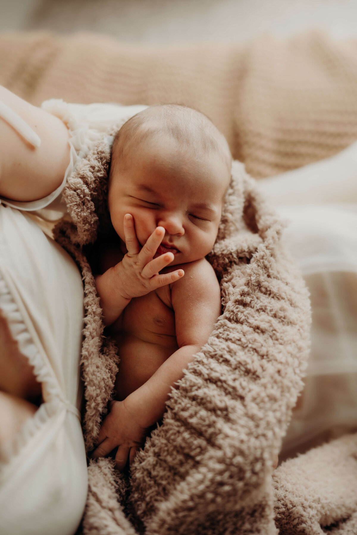 infant peacefully sleeps in his mothers arms