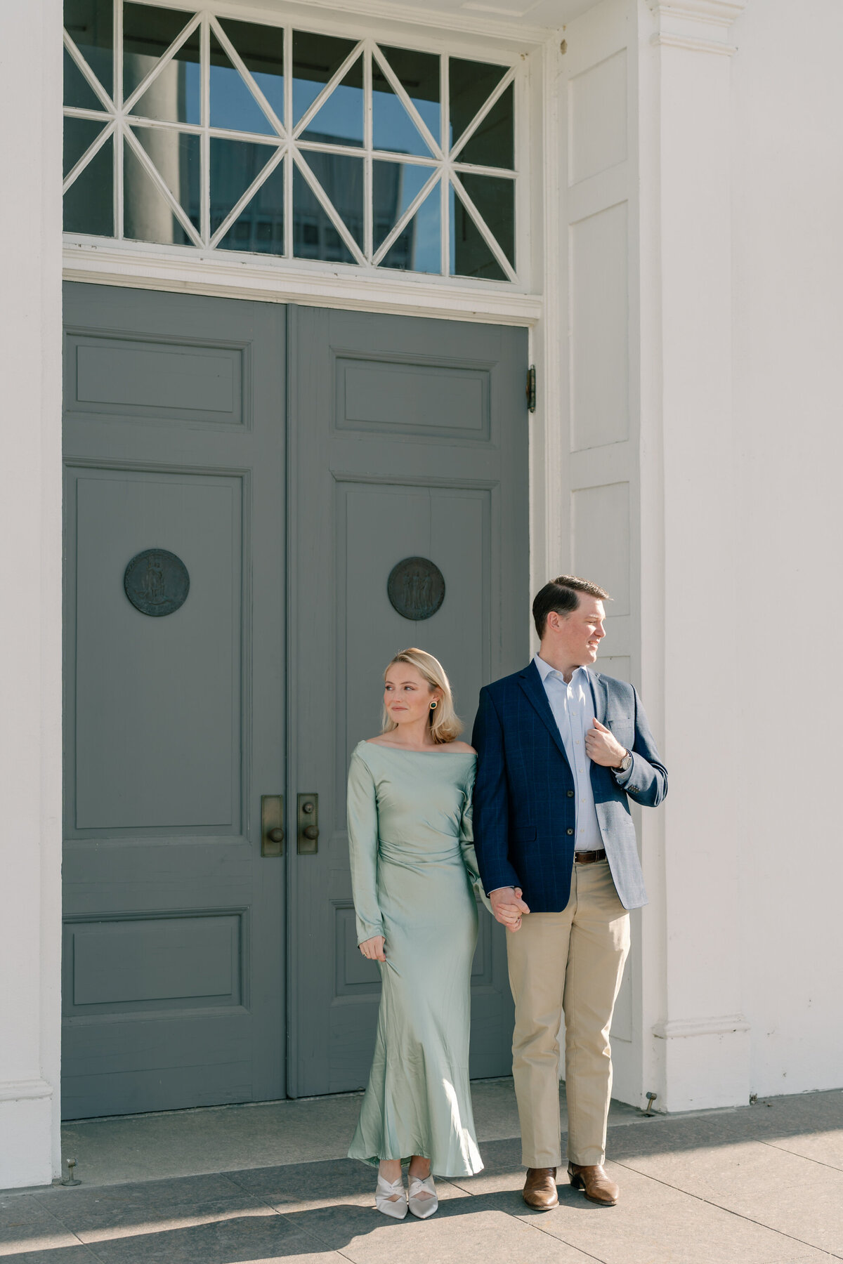 Virginia Capitol Building Engagement Session Richmond VA | couple stands hand-in-hand in front of the grand doorway at the Virginia Capitol Building
