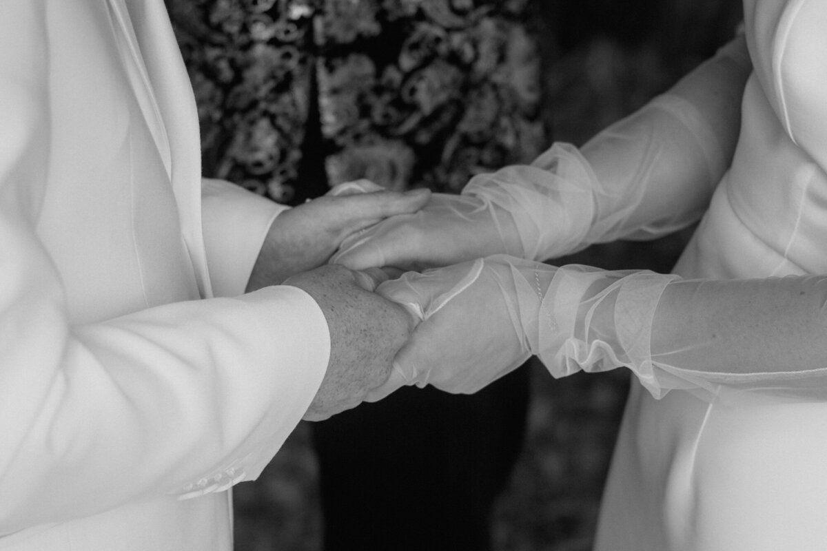 Während der Ehegelübde hält das Hochzeitspaar sich gegenseitig fest an den Händen.