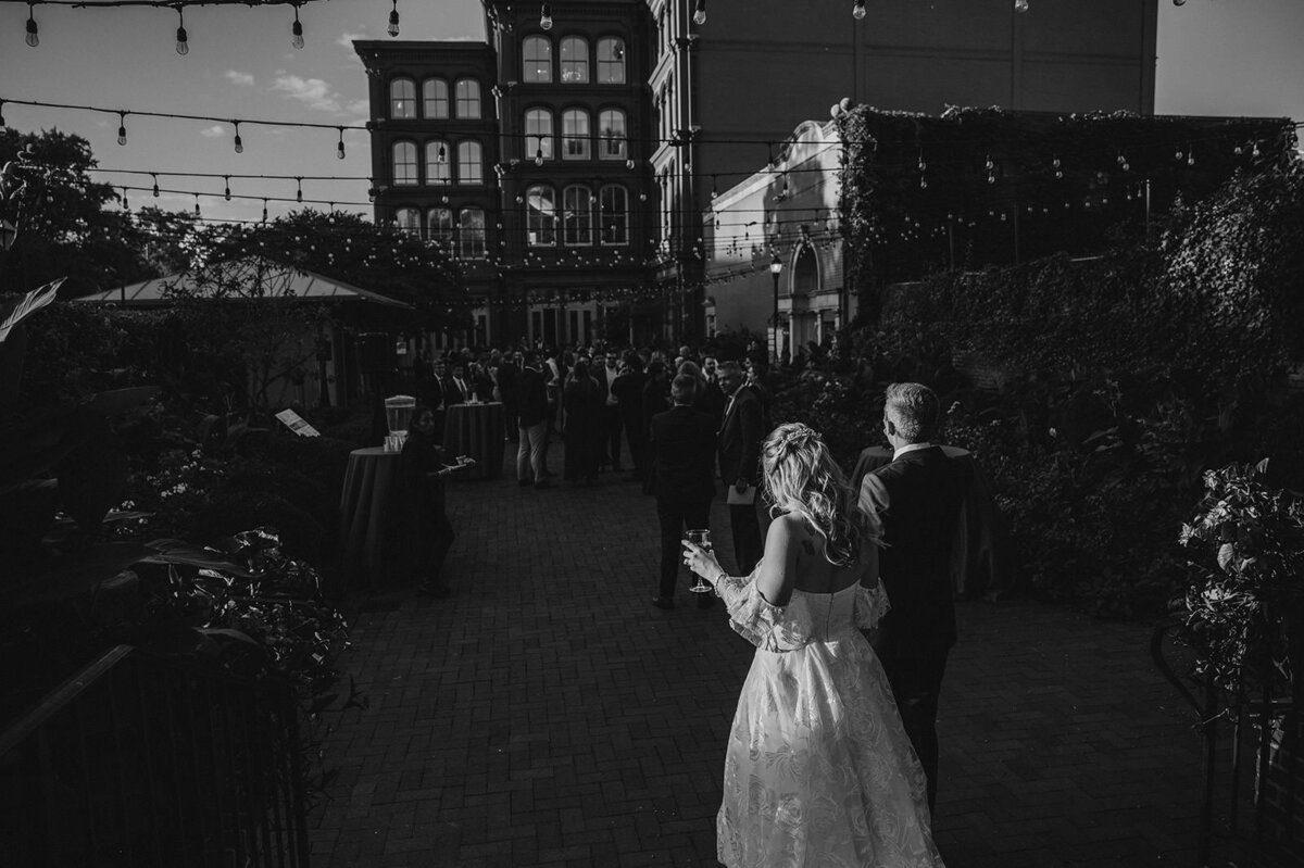 A wedding couple walking into their cocktail hour 