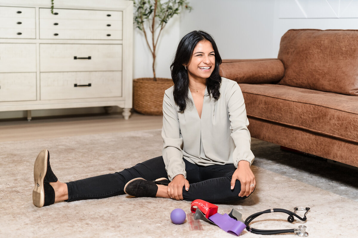 brand photo of a physical therapist sit in the floor among workout equipments