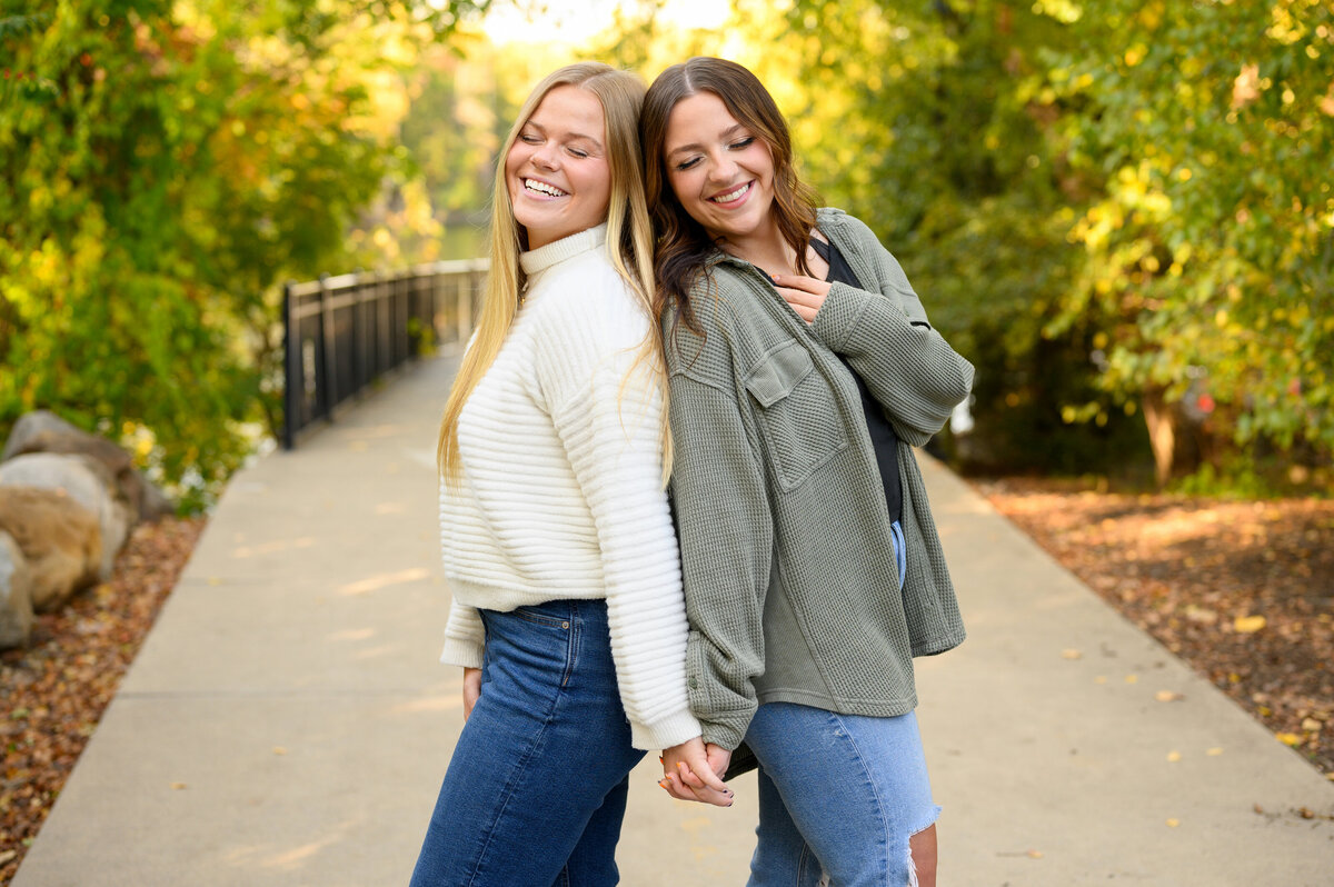 Best friends sharing smiles and laughter in a scenic autumn walk, beautifully captured by Leslie Q Photography