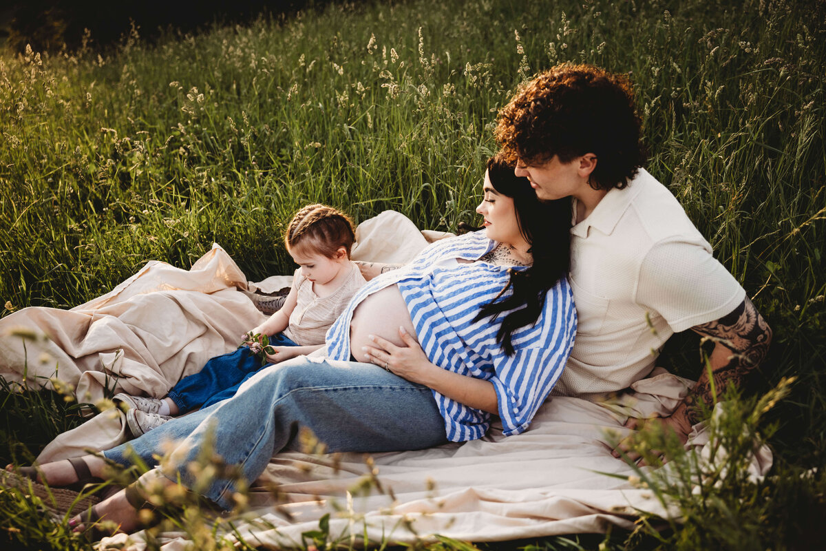 family sitting on blanket in portrait session with reva davis photography