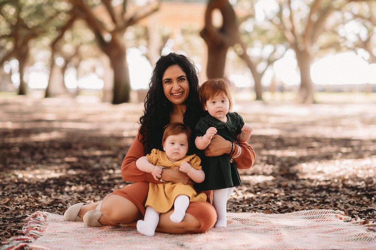 Mother embraces her twin babies during Family Portraits at White Point Garden in Charleston.