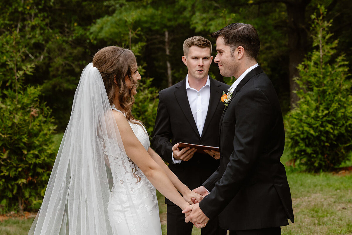 A couple holding hands as they say their vows